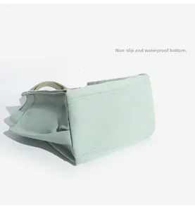 Detail view of the mint green canvas tote bag featuring an anti-slip and waterproof bottom