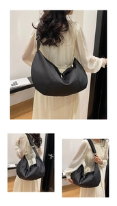 Detail view of large black crescent nylon crossbody bag with adjustable wide shoulder strap