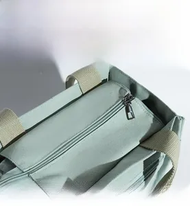 Close-up of a high-quality metal zipper closure on a green canvas tote lunch bag