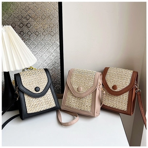 Straw weave crossbody bags in black, pink, and brown displayed on a white surface