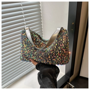 Détail de paillettes dégradées sur un sac à bandoulière demi-lune avec une chaîne argentée