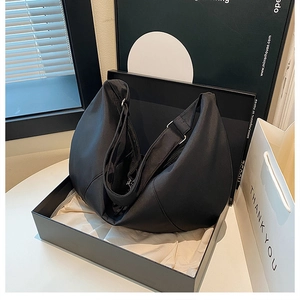 Detail of minimalist black moon bag in a gift box with white tissue paper and silver hardware