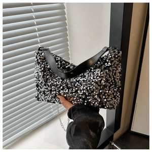 Détail du sac sous le bras à paillettes noires avec double chaîne argentée et cuir