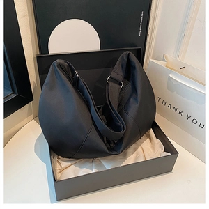 Minimalist black nylon dumpling bag presented in a premium black gift box with a thank you bag