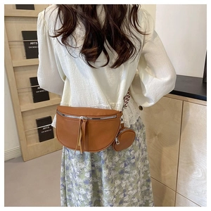 Brown litchi grain crescent crossbody bag with ethnic style strap and coin purse detail
