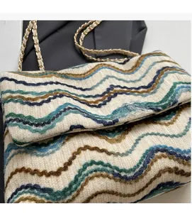 Macro shot of knitted wave pattern texture and gold chain strap on flap shoulder bag