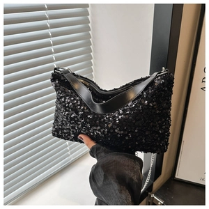 Détail du sac à main à paillettes noires avec surface réfléchissante et chaîne en métal