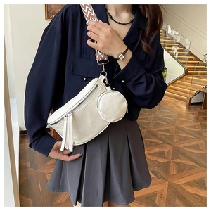 Detail of white crossbody chest bag with wave-patterned strap and mini coin pouch