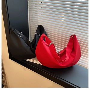 Detail of red and black nylon crescent bags showing spacious interior and silver hardware