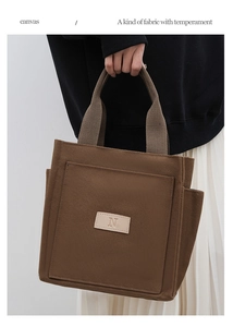 Detailed view of dark brown canvas tote bag with thick strap and minimalist N logo