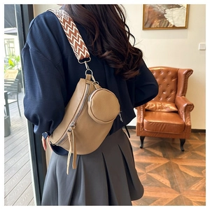 Detail view of khaki pebbled leather crossbody bag with geometric wide strap and mini pouch