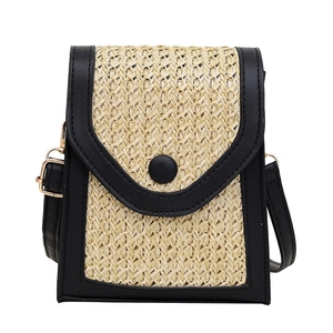 Fashionable woven straw and black leather crossbody bag with golden metal hardware