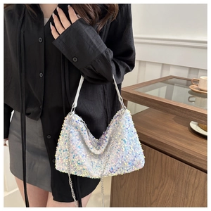 Détail des paillettes scintillantes sur un sac à bandoulière blanc avec chaîne argent