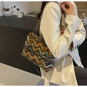Detail of colorful zigzag knit pattern on the flap with metallic chain and leather strap
