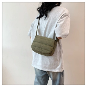 Vista trasera de modelo con un bolso bandolera acolchado verde militar para uso diario