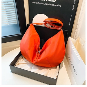 Vibrant orange nylon crescent bag displayed in premium gift box packaging for styling