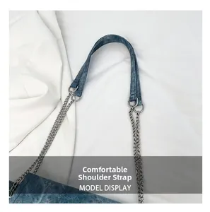 Detail view of denim tote bag featuring silver chain strap with comfortable shoulder pad