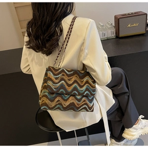 Detailed view of the plaid textured crossbody bag with silver metal chain strap for women