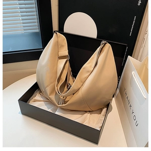 Elegant cream crescent bag presented in a luxury gift box with premium silk lining