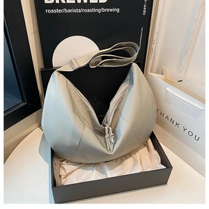 Detailed view of silver grey crescent bag with satin finish and adjustable wide strap