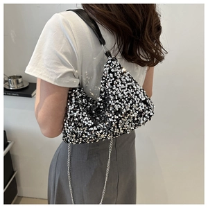 Détail du sac à paillettes montrant la texture bicolore et la bandoulière chaîne