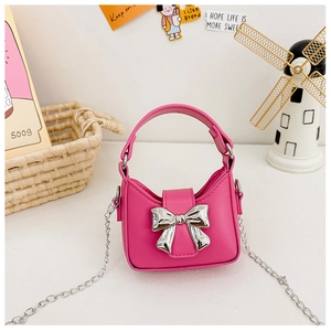 Detail of pink mini handbag for girls featuring a silver mirror bow and metal chain strap