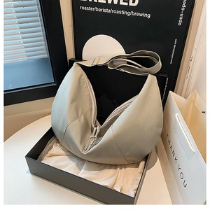 Detail view of light green crescent nylon bag with adjustable strap and gift box packaging