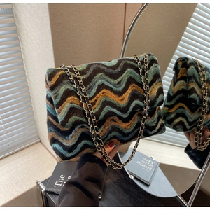 Detail of colorful wavy knit fabric and gold metal chain strap on flap bag