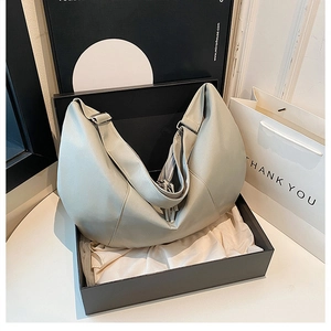 Detail view of sage green large capacity half-moon crossbody bag in luxury gift box