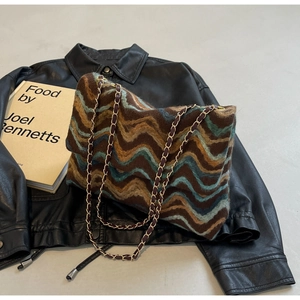 Close-up of knit tote bag featuring wavy retro patterns and premium metal chain strap