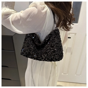 Détail de paillettes noires scintillantes et chaîne métallique sur un petit sac