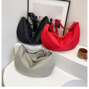 Detailed view of crescent tote bags in black, red, and grey with adjustable wide straps