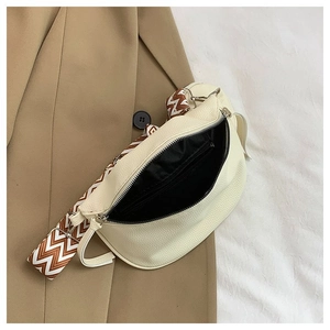 Detailed interior of beige pebbled leather crossbody bag with wave patterned wide strap