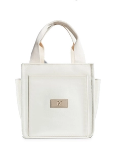 Minimalist white canvas tote bag with side pockets and elegant leather brand label
