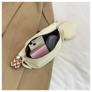 Detail view of cream lychee texture crossbody bag with coin purse and strap