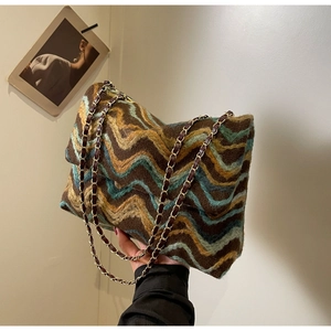 Detail of wavy knit fabric texture and dual chain strap on a vintage shoulder bag