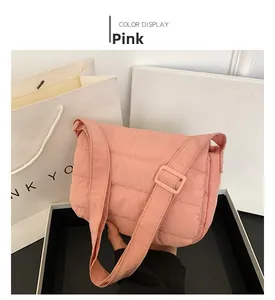 Detalle de bolso bandolera acolchado rosa con textura de rejilla y correa ajustable