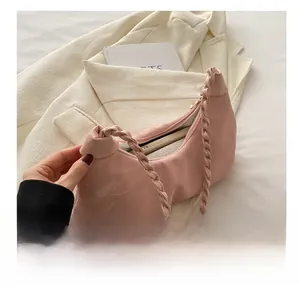Detailed capacity view of pink crescent cloud bag with woven strap on a white blazer