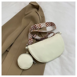 Close-up of beige crescent bag with geometric strap and matching small round coin purse