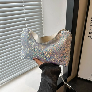 Sac hobo à paillettes irisées avec chaîne argentée et poignée blanche en pose élégante