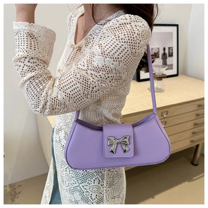 Détail du sac sous le bras en cuir lavande avec une boucle en forme de nœud argenté