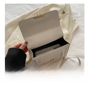 Detail view of beige leather crossbody bag interior showing phone and wallet capacity