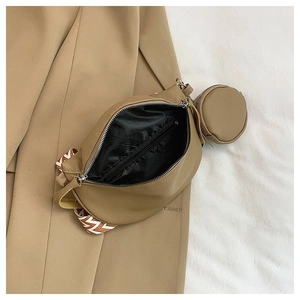 Detailed shot of litchi leather crossbody bag with interior zipper pocket and mini coin purse