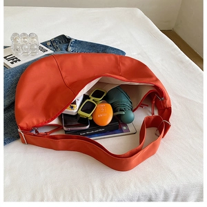 Orange crescent crossbody bag interior showing spacious storage for daily essentials