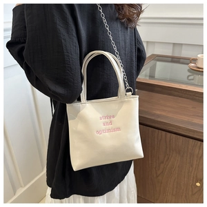 Détail du mini sac en cuir blanc crème avec broderie rose strive and optimism