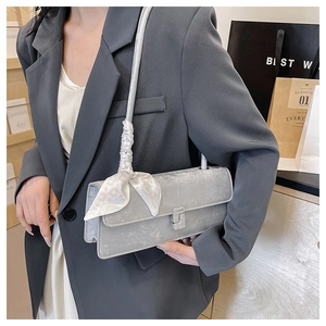 Détail du sac à main gris argenté avec boucle en cristal et foulard en soie décoratif