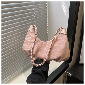 Detail view of pink ruched hobo bag with woven handle and moon cloud texture surface