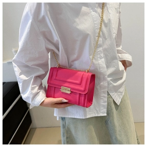 Close-up of rose pink crossbody bag featuring gold chain strap and H-shaped embossing