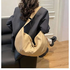 Khaki Hobo crossbody bag showing large capacity and drape effect on a model's back