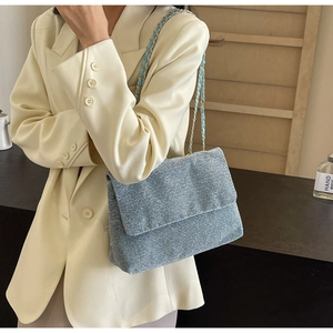 Detail of light blue glitter tote bag showing woven chain strap and shimmer texture